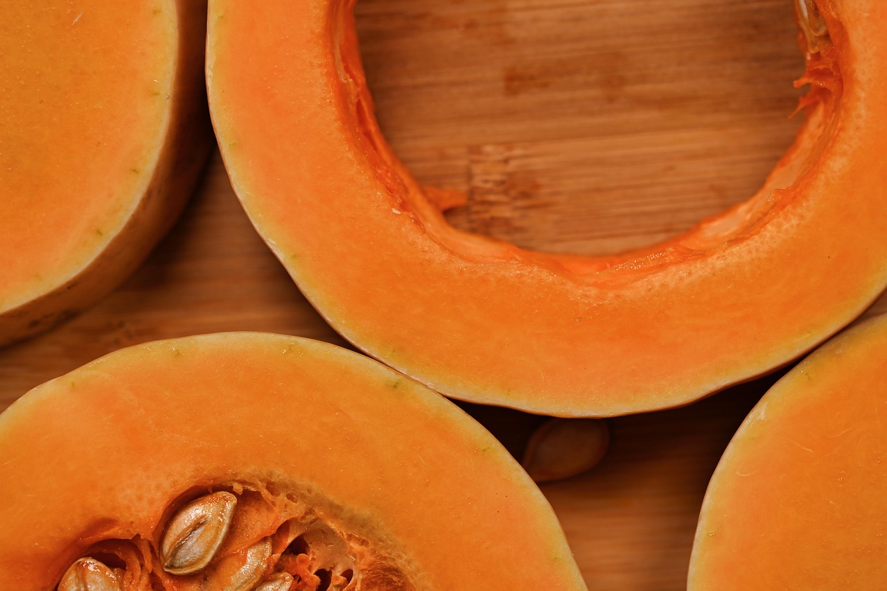 Autumn butternut squash halves on a wooden board, ready for roasting.