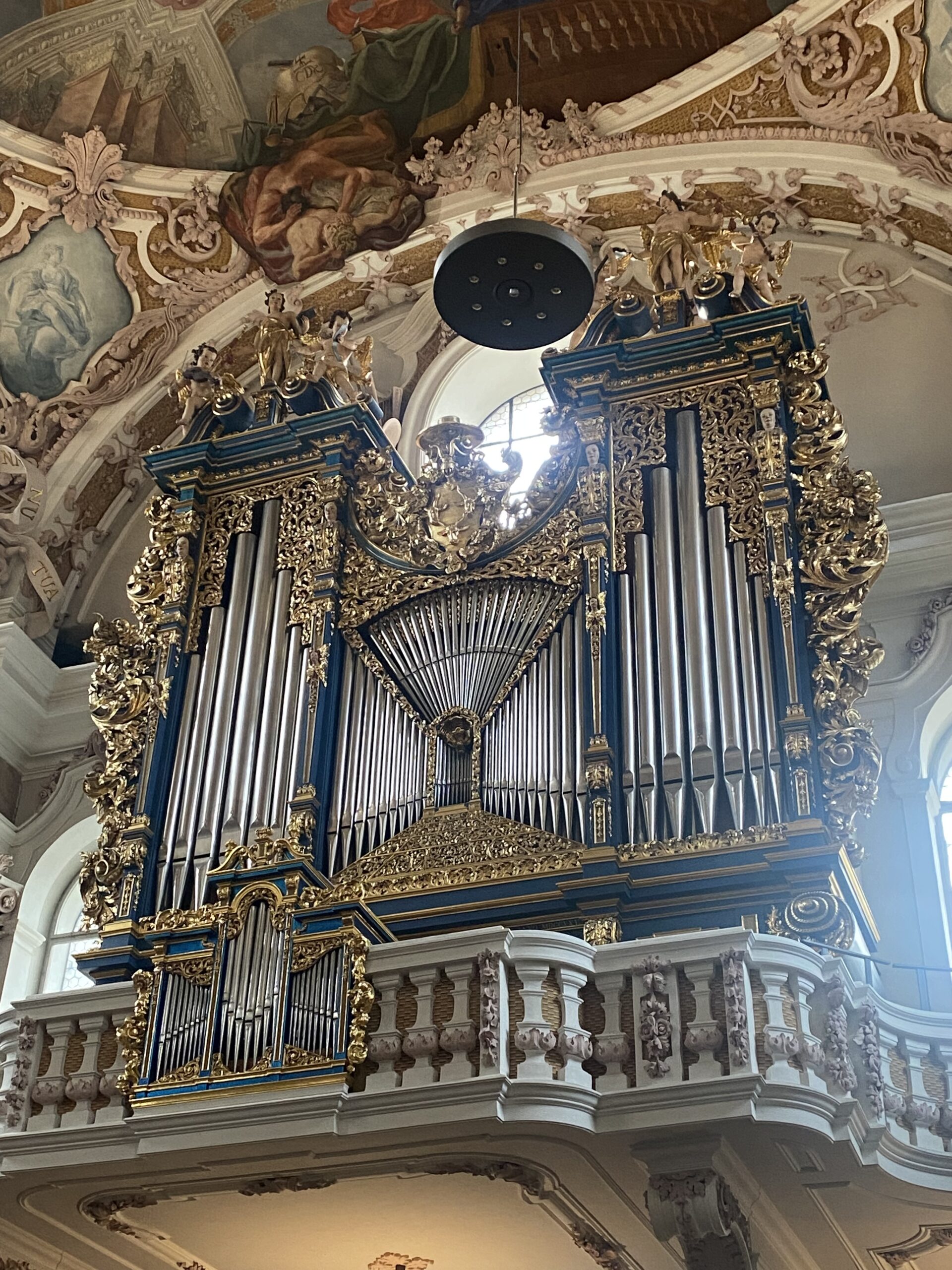 Ornate pipe organ inside a historic Catholic church in a small alpine village.